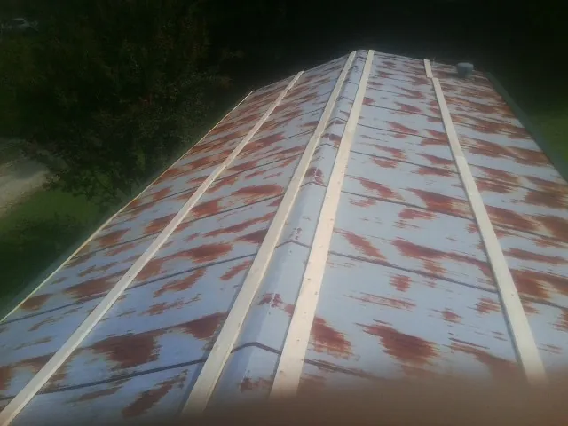Rusted metal roof panels with new wood purlins before replacement — Storm Damage Roof Repair in Fruitport by Roofing Brothers