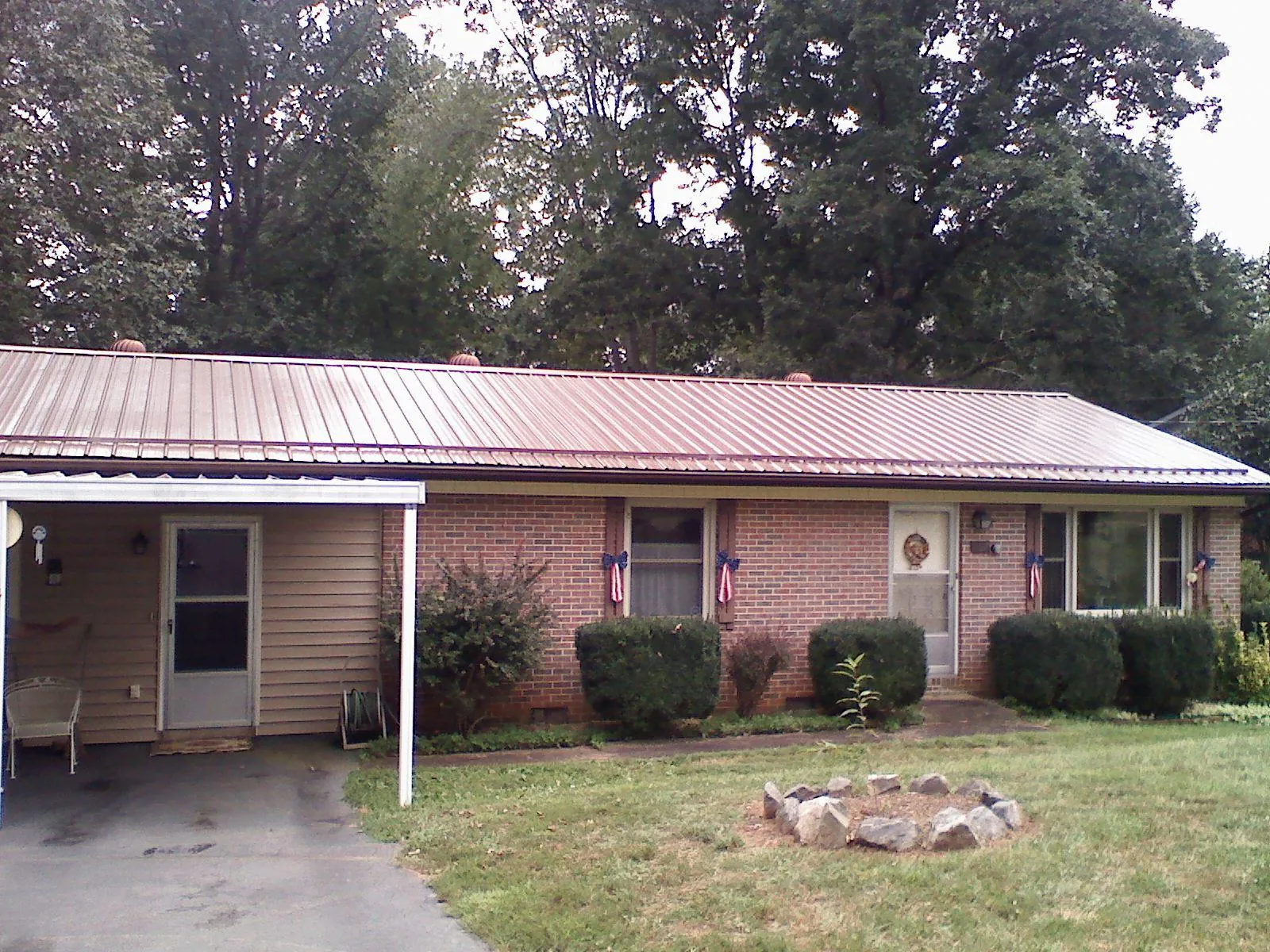 Bronze metal roof and carport on a brick ranch home — Roof Repair work by our crew in Fruitport